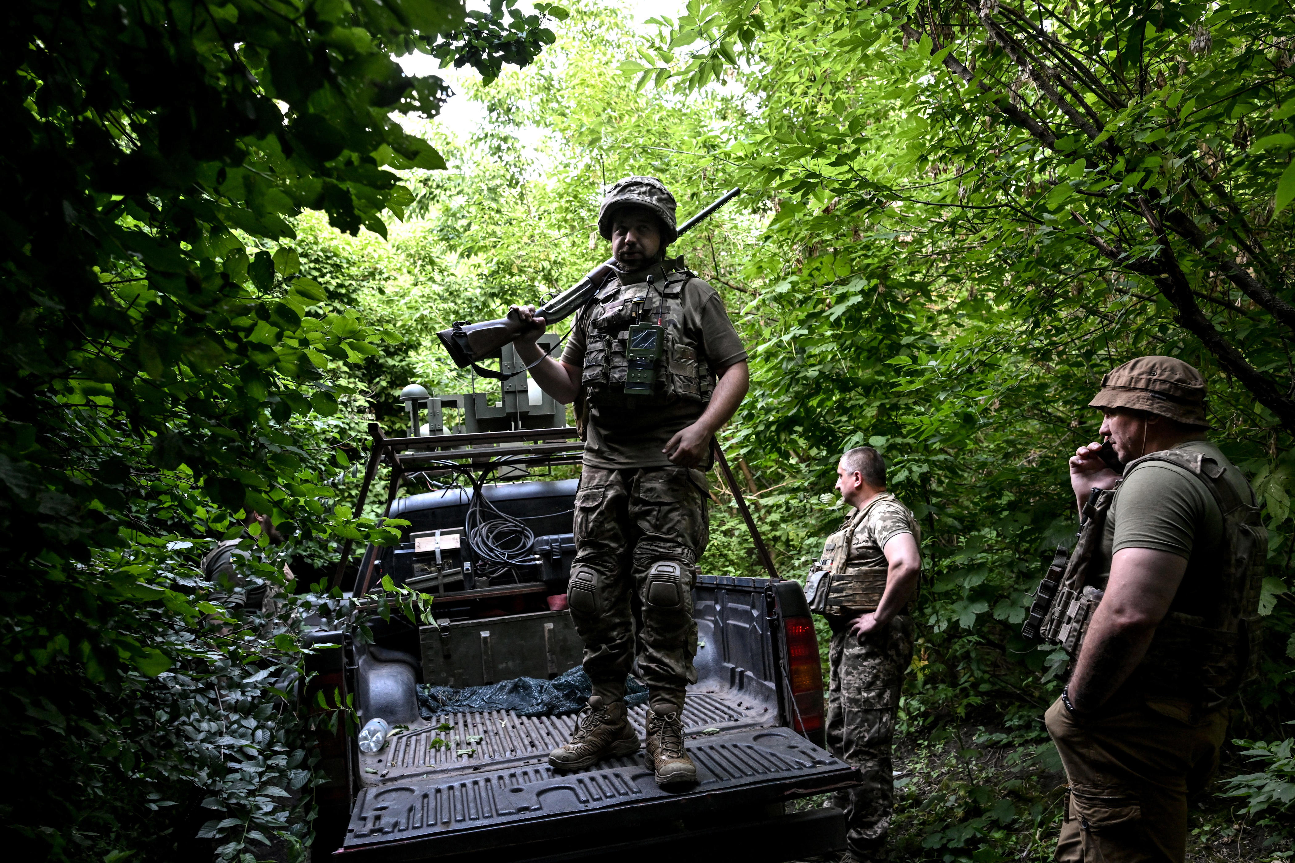 Soldiers from the 148th Separate Artillery Zhytomyr Brigade of the Ukrainian Airborne Forces take cover in the shadows of trees in the Dnipropetrovsk region, Ukraine, on June 22, 2026.