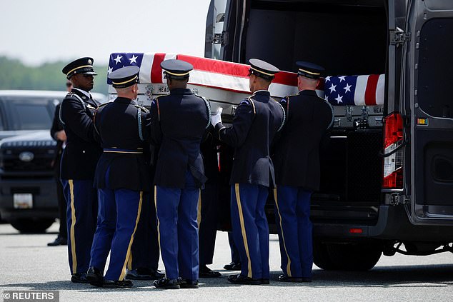 Members of the military carry the transfer case to the transport van during a dignified transfer