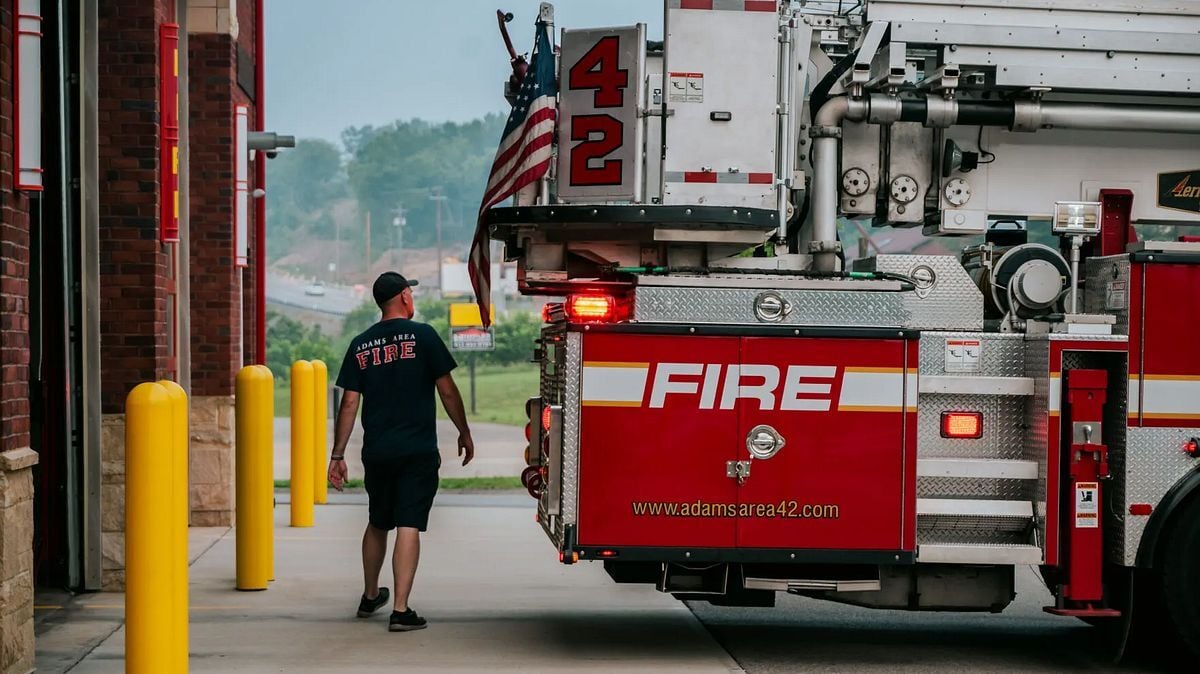 A firefighter walks beside a fire truck outside a fire station. Photo: Grace David / The Center Square