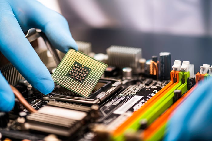 A latex glove holding a computer chip.