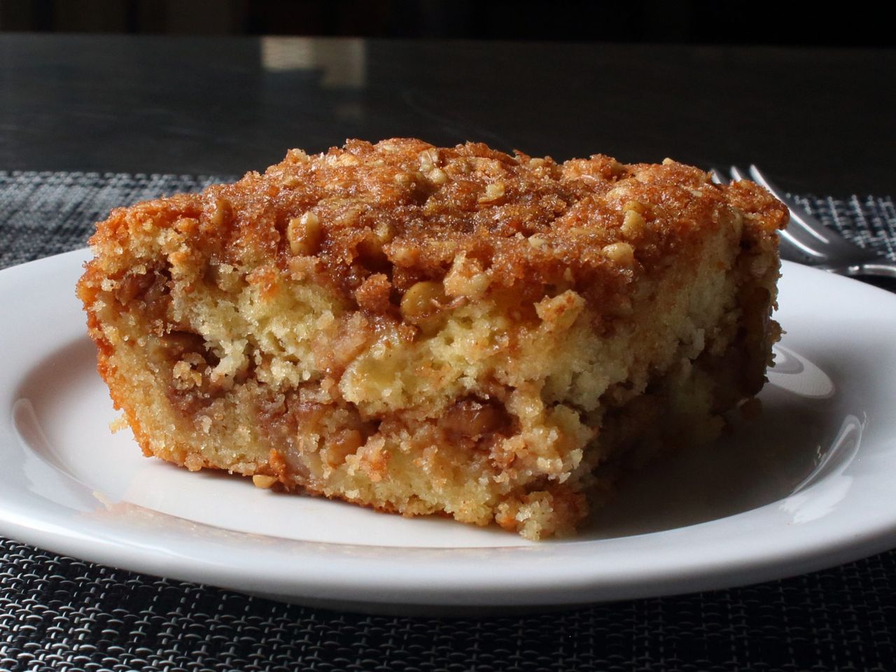 a slice of coffee cake with a streusel crumble on top and in the center