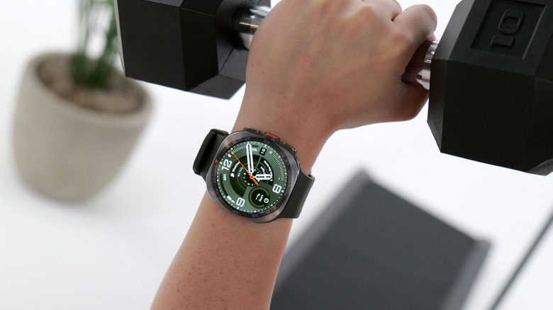 The Galaxy Watch Ultra 2 on the wrist of a person gripping a dumbbbell.