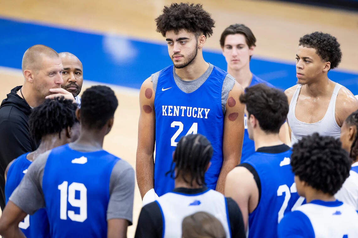 Malachi Moreno, center, listens to coach Mark Pope during a recent UK basketball practice.