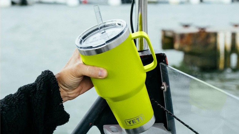 A hand holds out a Yeti water bottle.