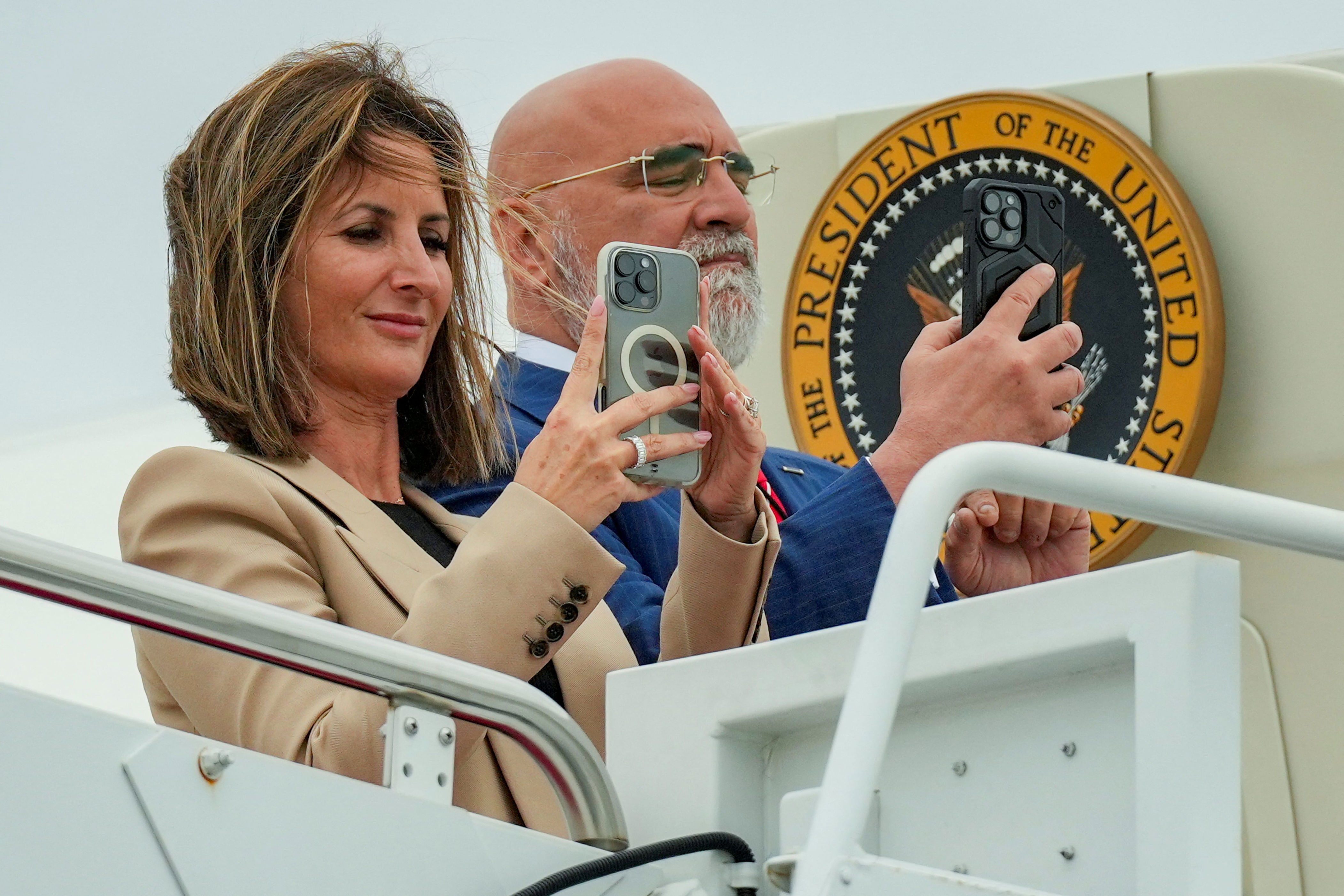 Trump Campaign Finance Director Meredith O’Rourke and American political consultant, Chris LaCivita, take pictures of U.S. President Donald Trump as he arrives on Marine One at Joint Base Andrews, in Maryland U.S., August 1, 2025. REUTERS/Ken Cedeno / Ken Cedeno / REUTERS