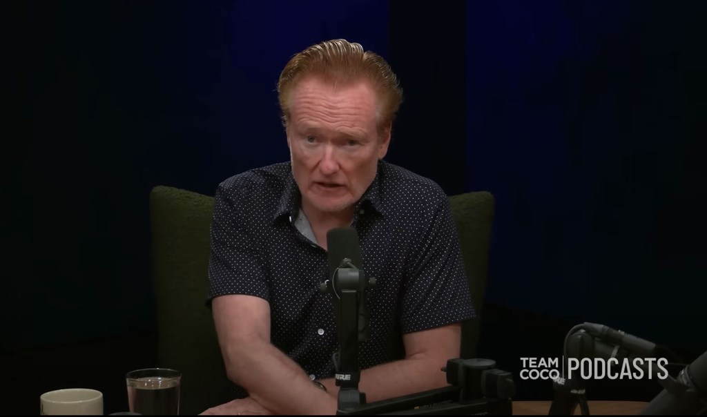 Conan O'Brien speaking into a microphone.