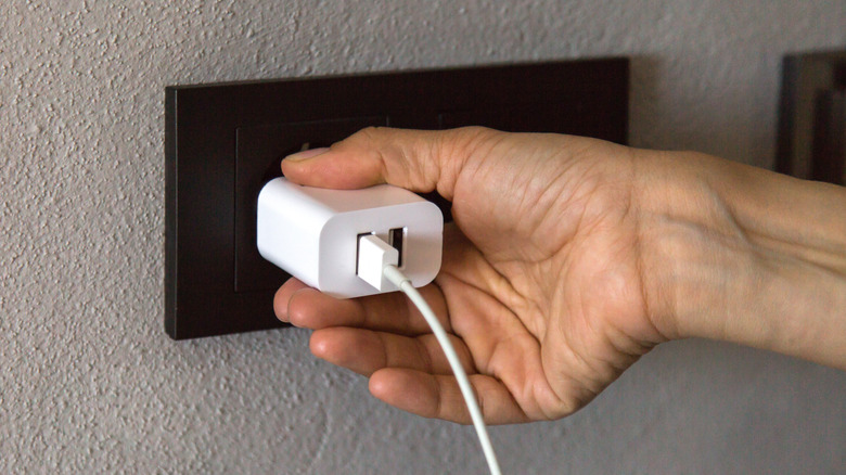 Plugging in an adapter in a wall outlet
