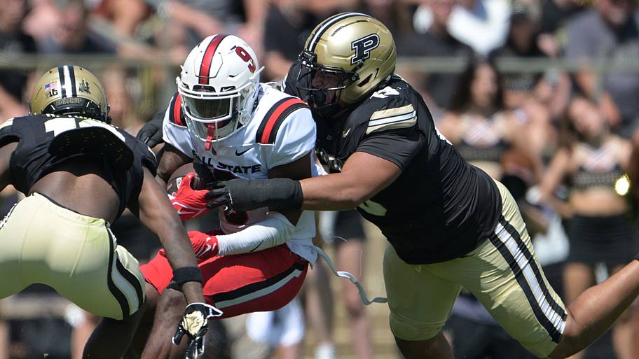 Ball State Cardinals running back Qua Ashley (9) is tackled by Purdue Boilermakers defensive lineman TJ Lindsey (13).