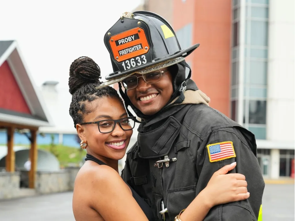 Newly engaged couple Dasia and Jayson embrace after the FDNY firefighter proposal in New York City.