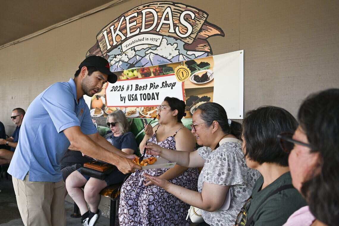 Derek Ikeda hands out sliced peaches for visitors to sample during an event organized by the California Museum at Ikeda’s in Auburn on Sunday, July 19, 2026. Ikeda’s was recently named the #1 best pie shop in America according to USA Today.