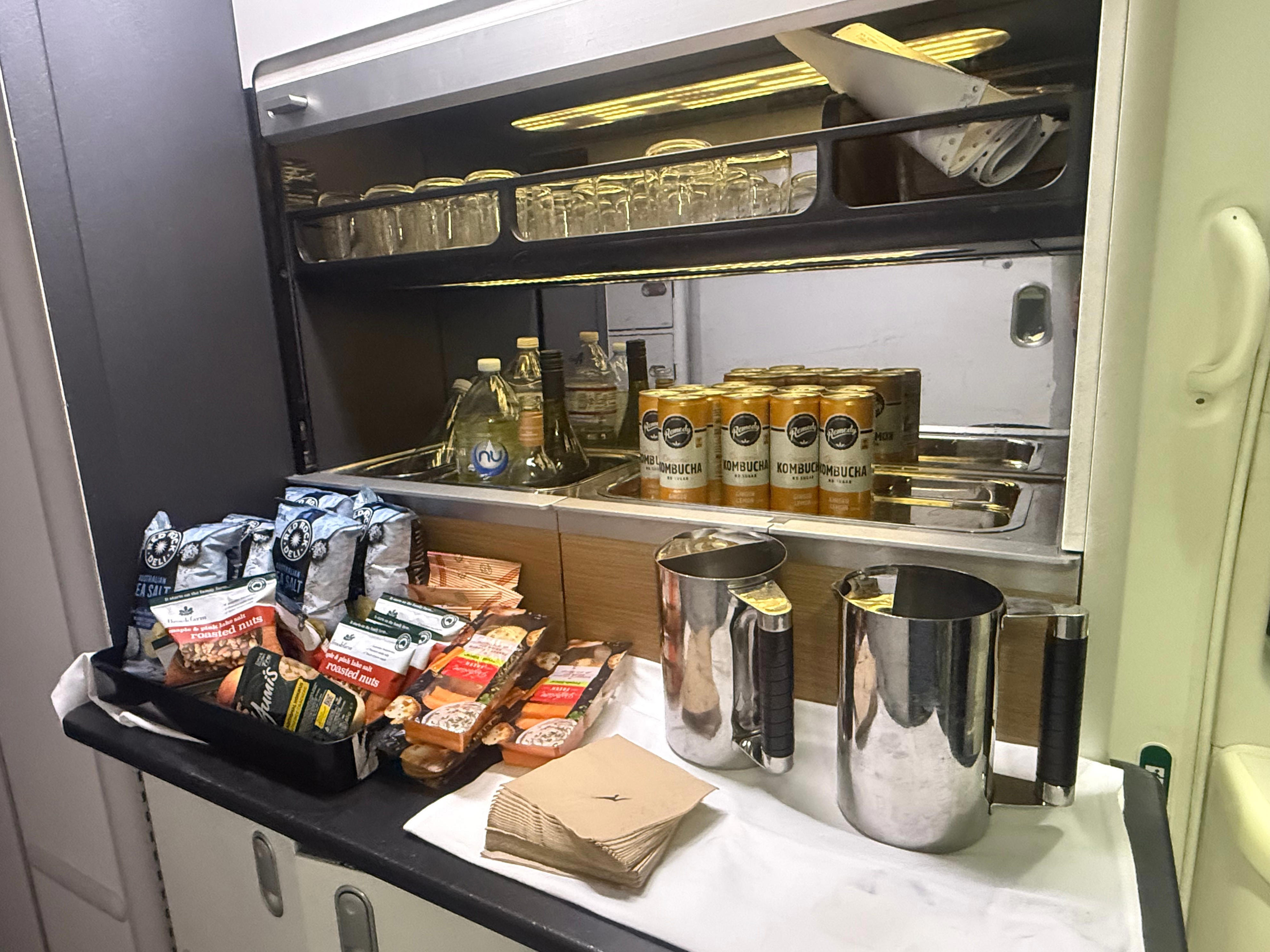Snack bar area with kombucha and other snacks and drinks on Qantas premium flight