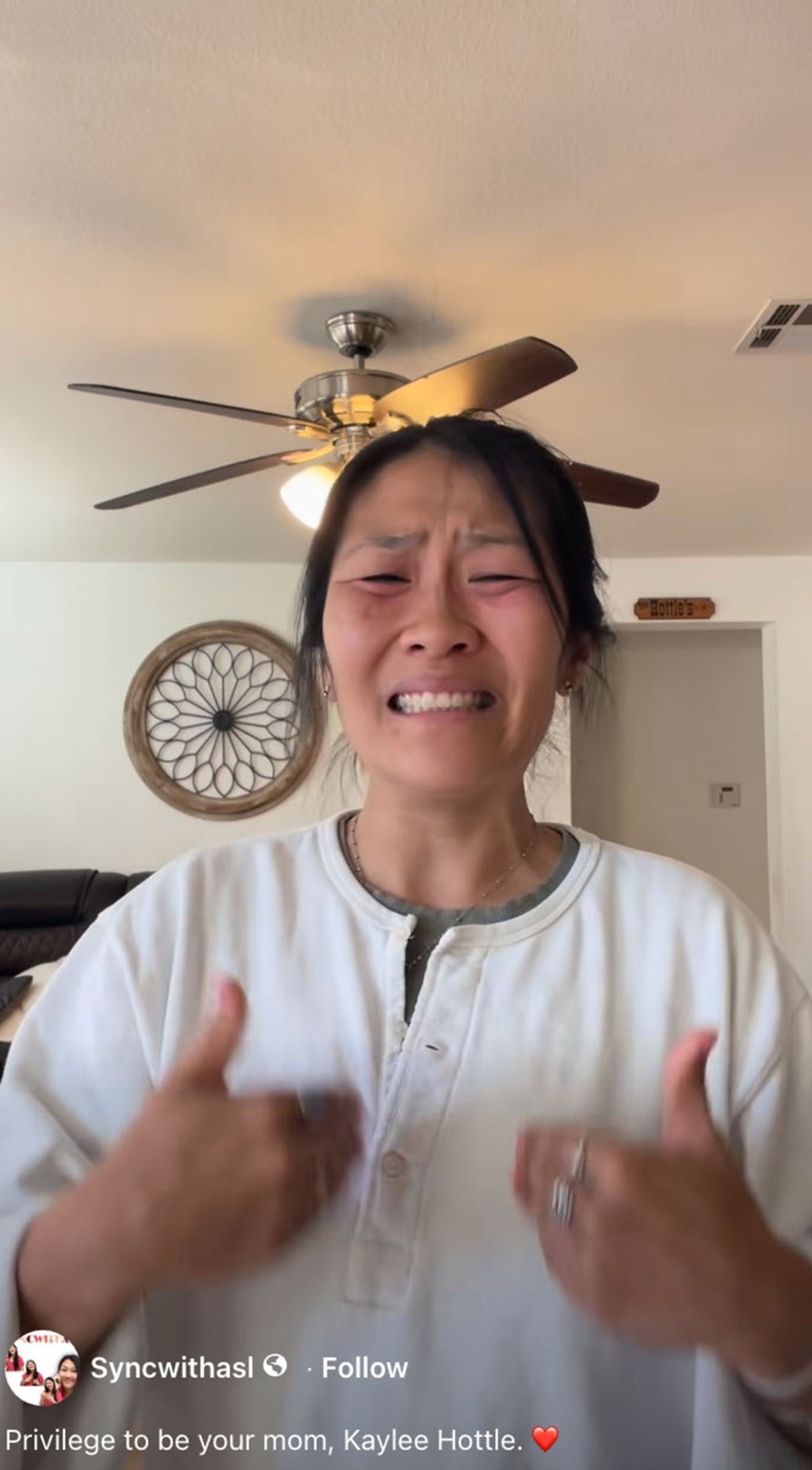 A woman crying with red eyes, forming tears, wearing a white button-up shirt and a necklace.