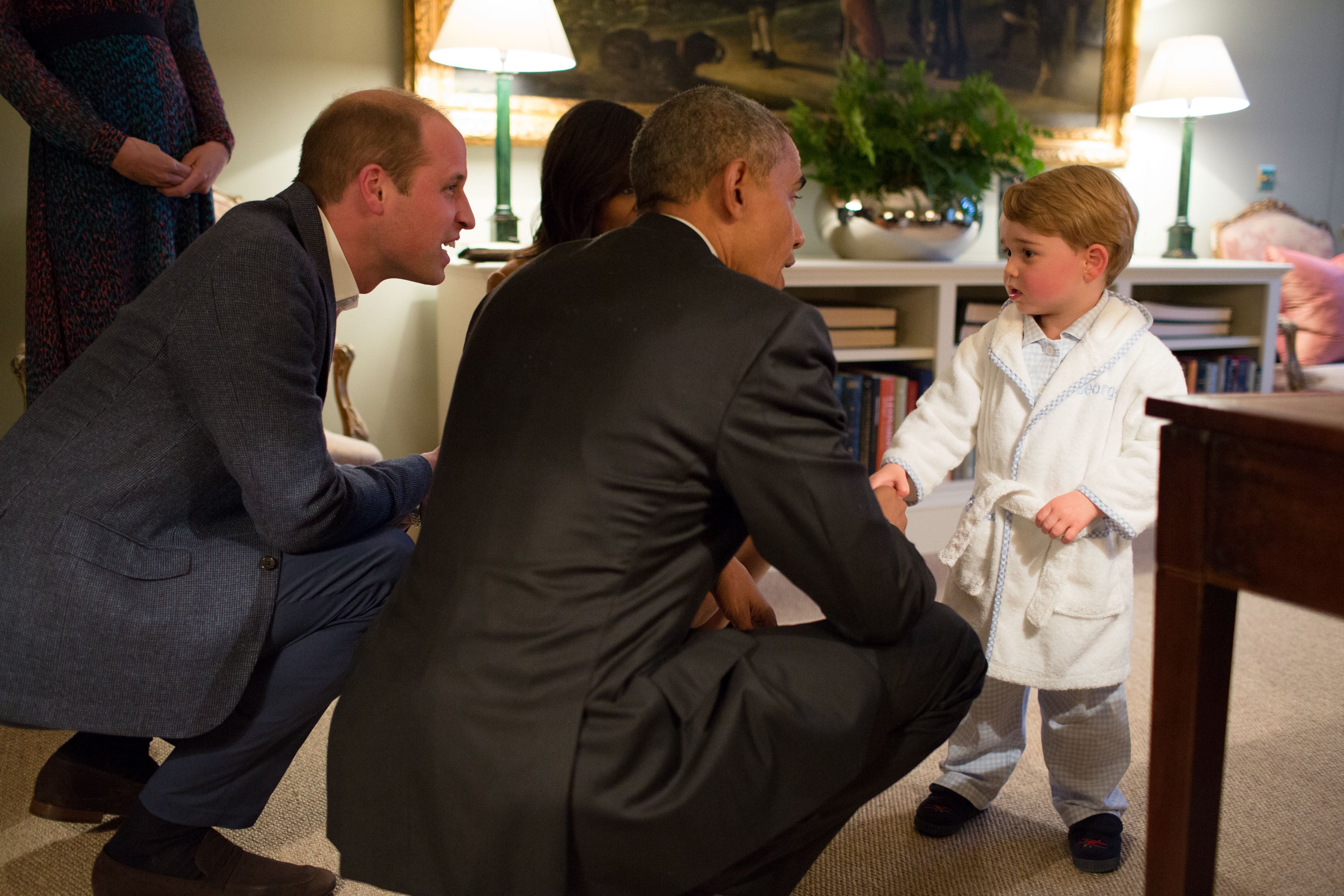 2016: In this handout provided by The White House, President Barack Obama, Prince William, Duke of Cambridge and First Lady Michelle Obama talks with Prince George at Kensington Palace on April 22, 2016, in London, England.