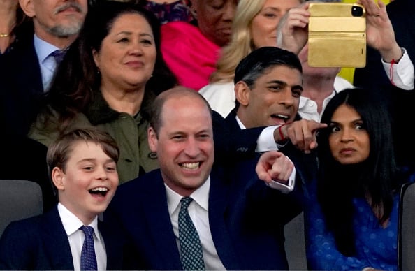 2023: (L-R) Prince George of Wales and Prince William, Prince of Wales, and Prime Minister Rishi Sunak and his wife Akshata Murty, during the Coronation Concert held in the grounds of Windsor Castle on May 7, 2023, in Windsor, England. The Windsor Castle Concert is part of the celebrations of the Coronation of Charles III and his wife, Camilla, as King and Queen of the United Kingdom of Great Britain and Northern Ireland, and the other Commonwealth realms that took place at Westminster Abbey yesterday. High-profile performers will entertain members of the royal family and 20,000 guests, including 10,000 members of the public. (Photo by Stefan Rousseau - WPA Pool / Getty Images)