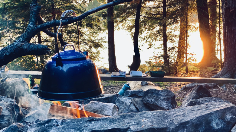 boling a kettle over a campfire while backcountry camping