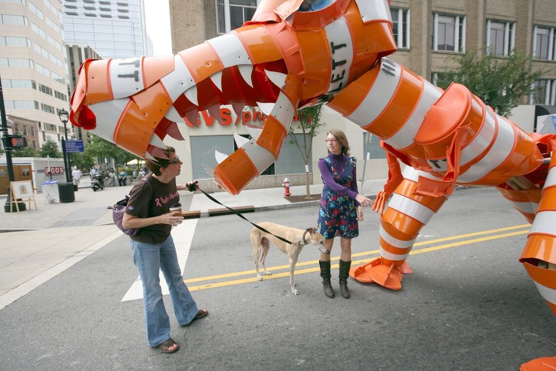 Sharon Felton (left) of Raleigh and her daughter Summer Felton ( right) get a close-up look at the new Barrel Dinosaur constructed on Hargett Street at Fayetteville Street by the same guerrilla artist that became famous for creating the other Barrel Monster on Hillsborough Street..