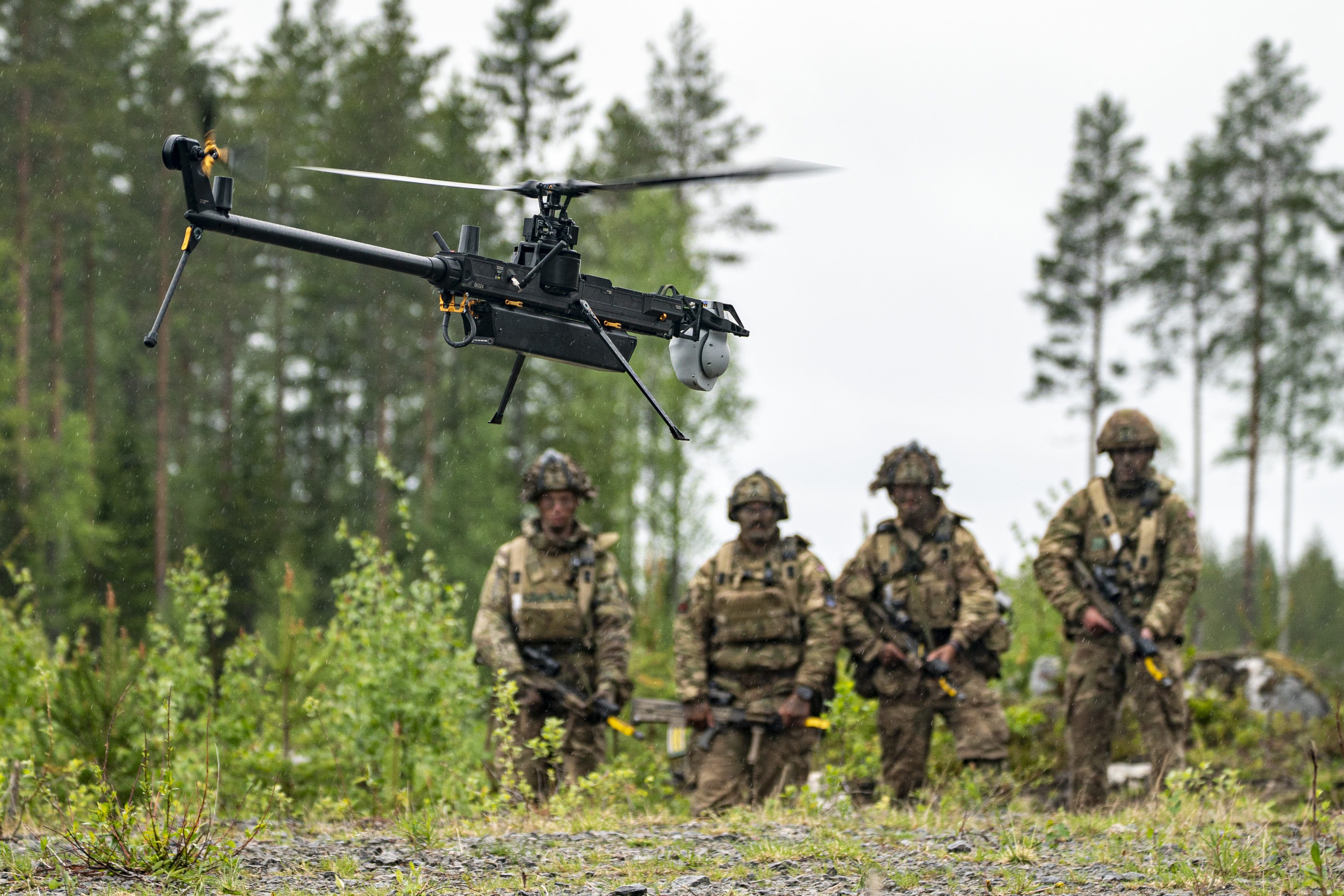 British Army soldiers from 3 Rifles watch a single-rotor helicopter-style Ghost drone.