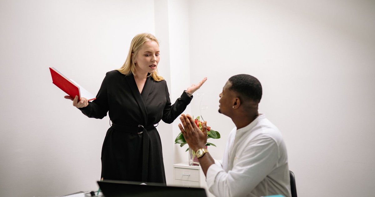 Colleagues in an animated discussion in an office setting, highlighting workplace communication.