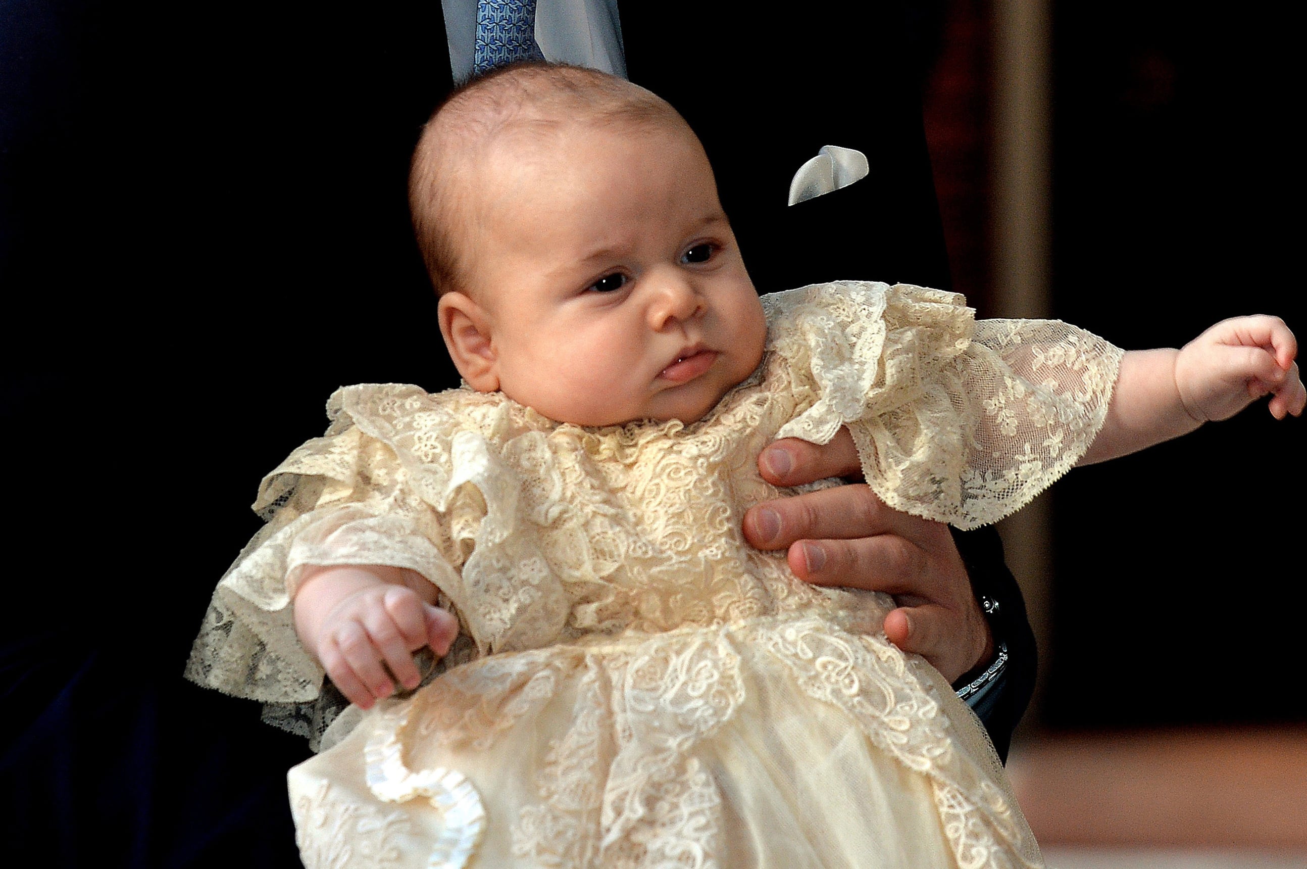 2013: Britain's Prince William, Duke of Cambridge, holds his son, Prince George of Cambridge, as he arrives at Chapel Royal in St James's Palace in central London for the christening of the three month-old baby on October 23, 2013.