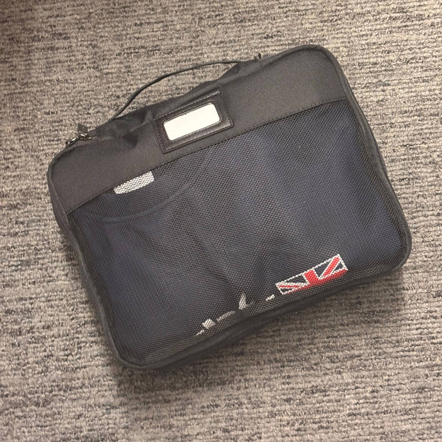 Small Calpak packing cube packed with a sweater on carpet. (Courtesy Cory Fernandez)
