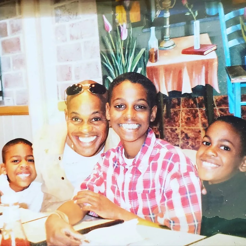 Jubilant Sykes smiling with his three sons.