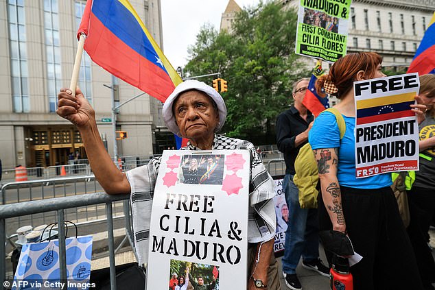 Demonstrators hold signs in support of ousted Venezuelan president Nicholas Maduro and his wife Cilia Flores outside the court on Wednesday