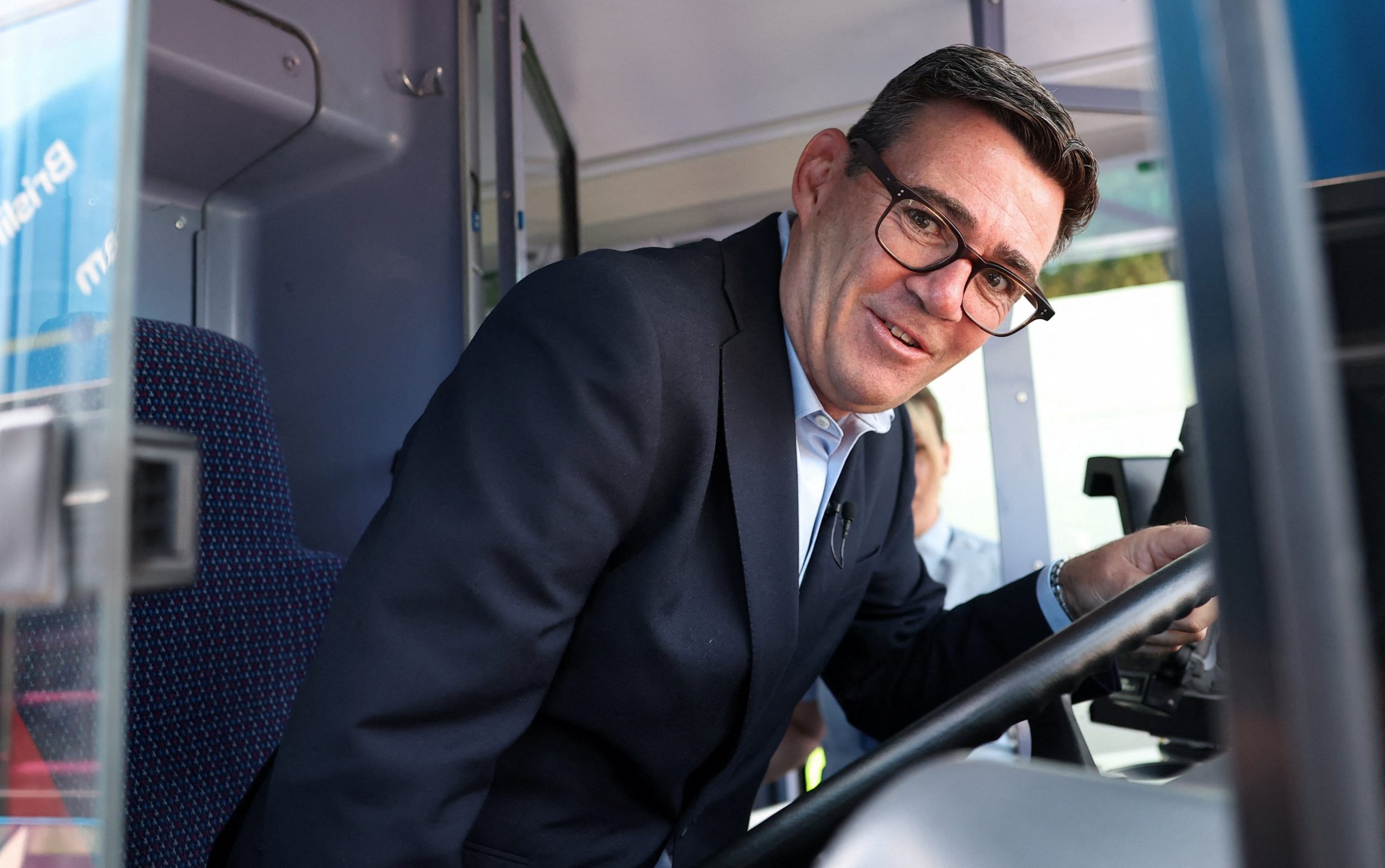 Andy Burnham poses in a bus