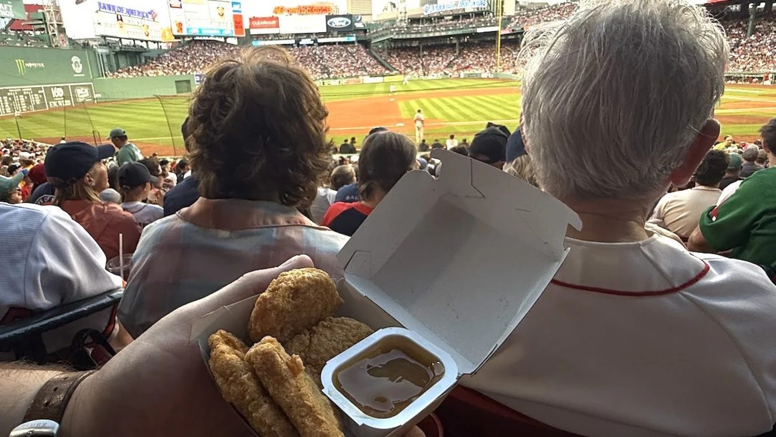 A 4-piece McNugget being held at a seat at Fenway Park during a Red Sox game