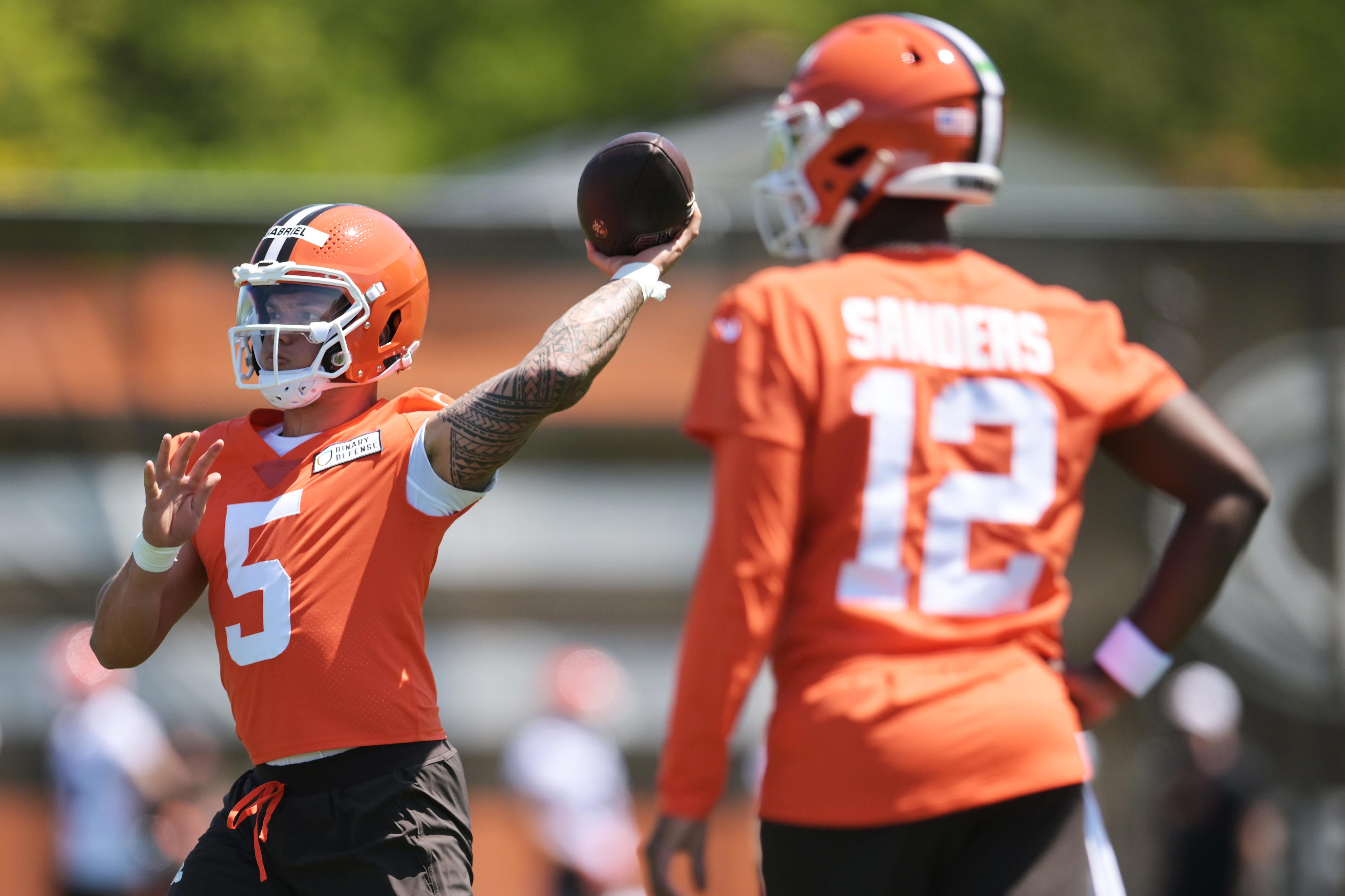 May 10, 2025; Berea, OH, USA; Cleveland Browns quarterback Dillon Gabriel (5) passes as quarterback Shedeur Sanders (12) looks on during rookie minicamp at CrossCountry Mortgage Campus. Mandatory Credit: Ken Blaze-Imagn Images