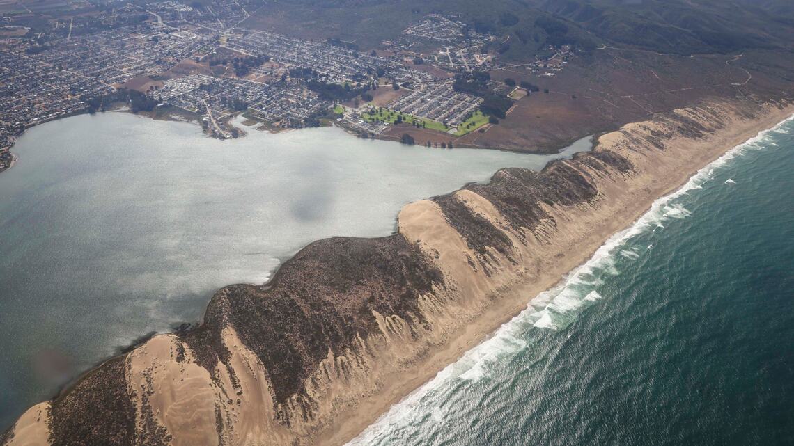 Sand dunes border the Morro Bay Estuary, spilling into Shark Inlet on the right.