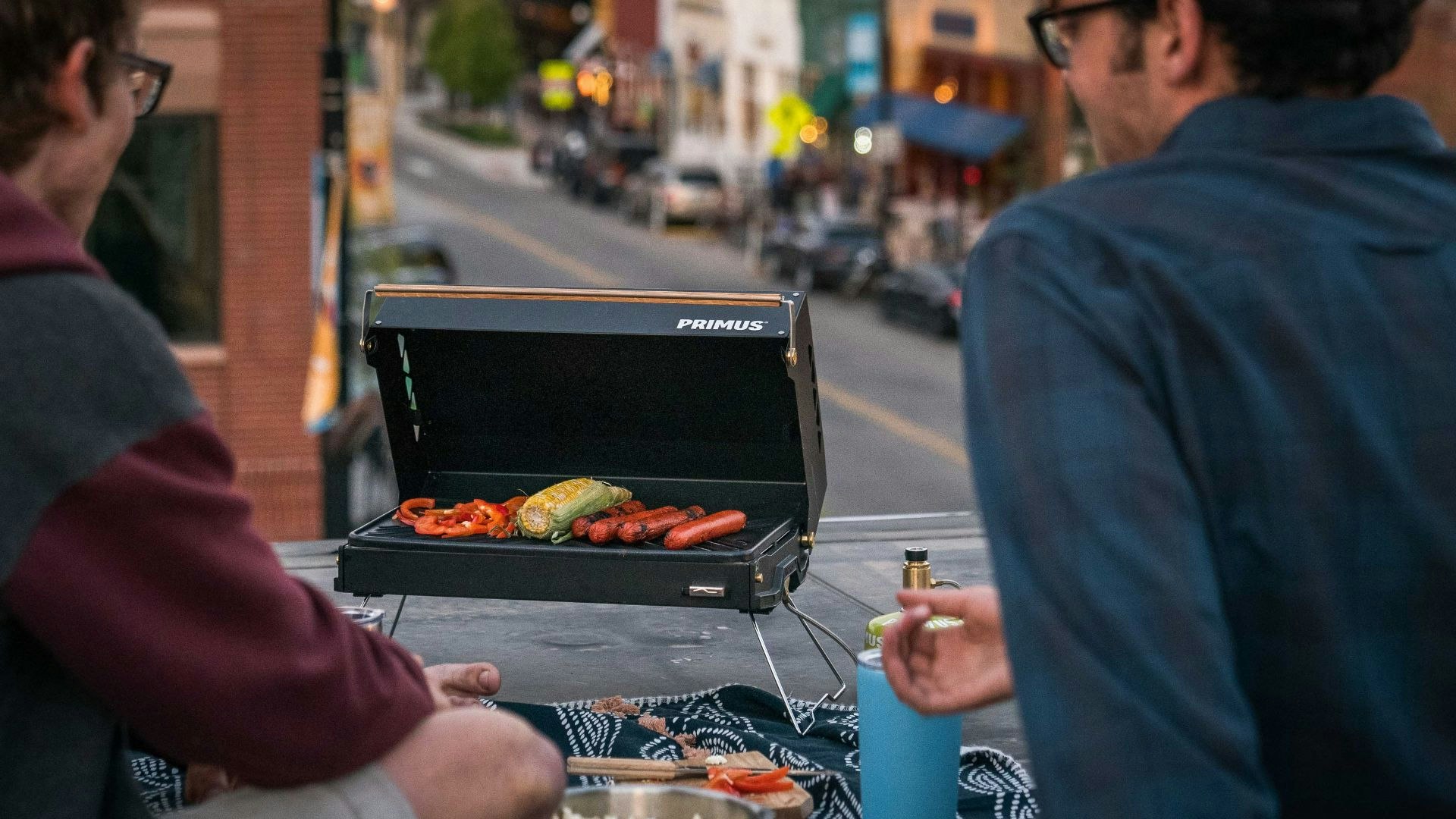 Two people cooking on the Primus Kuchoma grill