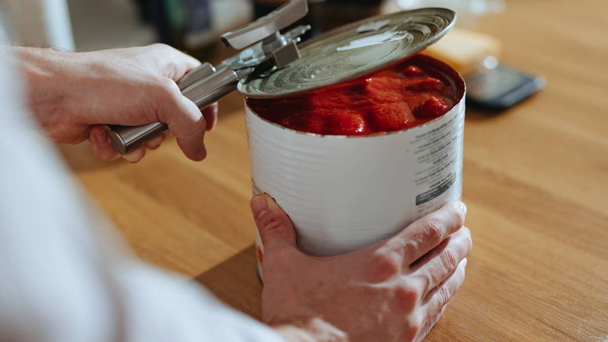 close-up-photo-of-mans-hands-opens-lid-of-canned-tomato-puree