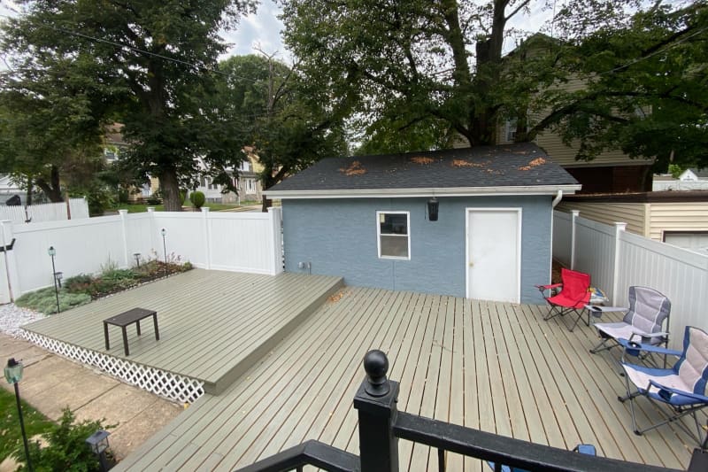 Gray wood deck with folding chairs during backyard renovation.