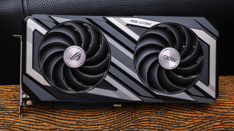 ASUS ROG Strix graphics card with dual cooling fans shown on a textured surface.