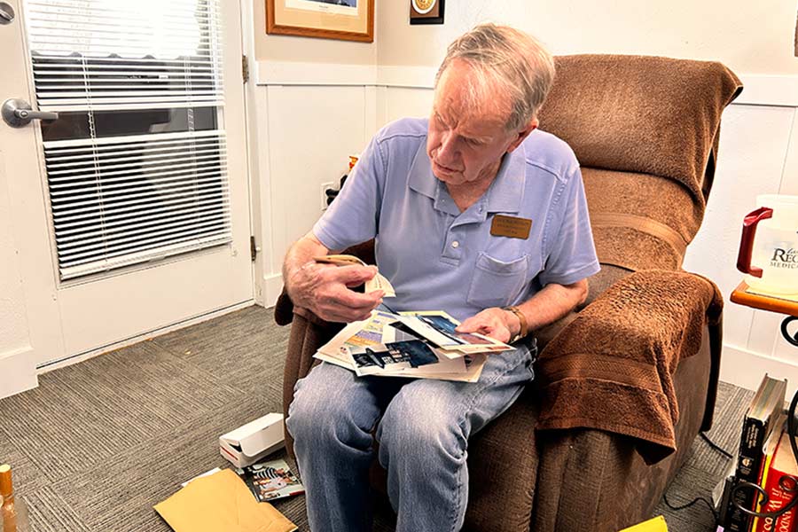 Jack Magnusson rifles through photos during a conversation with EastIdahoNews.com. | Rett Nelson, EastIdahoNews.com