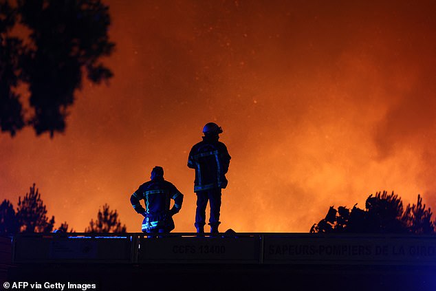 Firefighters monitor a wildfire in Le Porge, south-western France on July 22, 2026