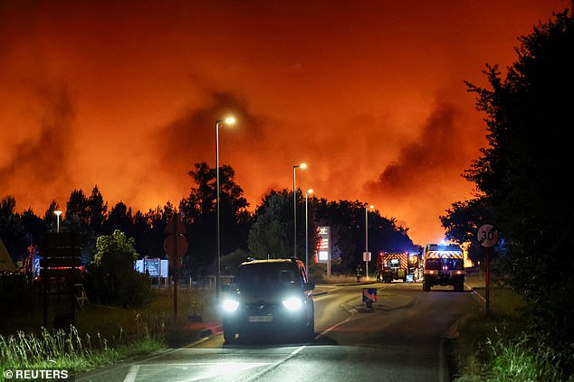 Emergency service vehicles on a road in Le Porge as a wildfire burns in a forest area in the Gironde department amid worsening drought conditions