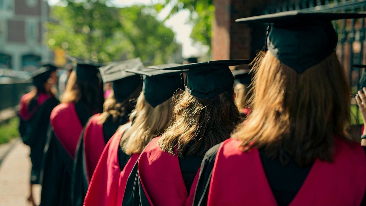 Graduates of Harvard Law School walk in procession wearing traditional red and black academic regalia during a commencement ceremony. Photo: Christian Lendl / Unsplash