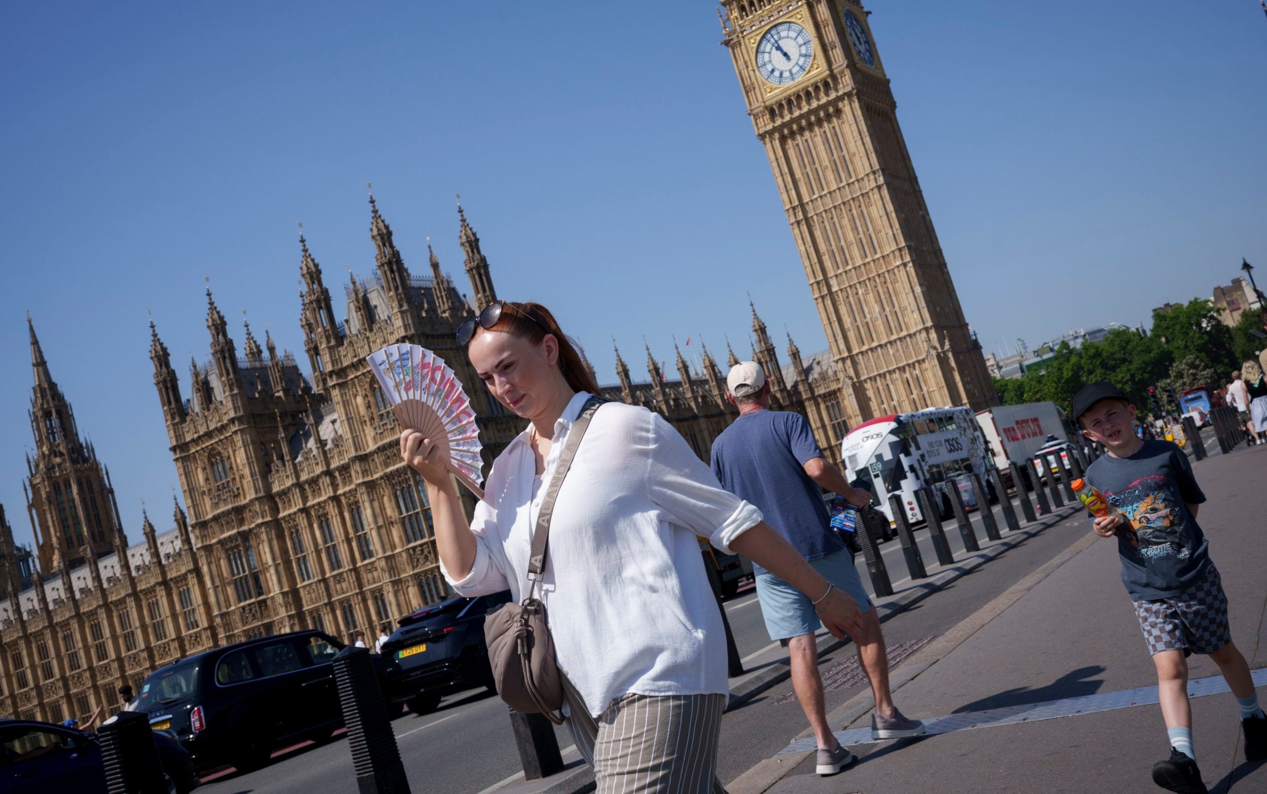As the hottest day in June is recorded, visitors to London walk over Westminster Bridge, 24 June 2026