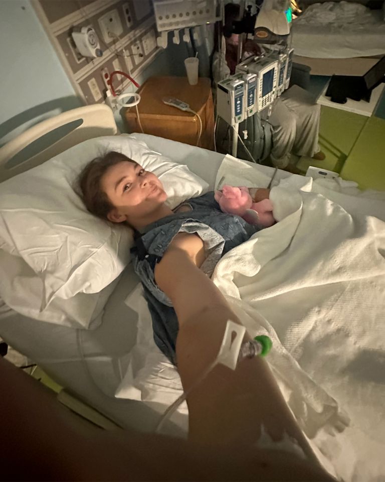 A person in a hospital bed holding a newborn