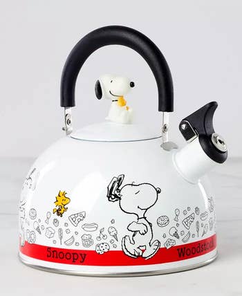 Snoopy-themed kettle with a lid handle shaped like Snoopy. Features cartoon illustrations of Snoopy and Woodstock, suitable for kitchens