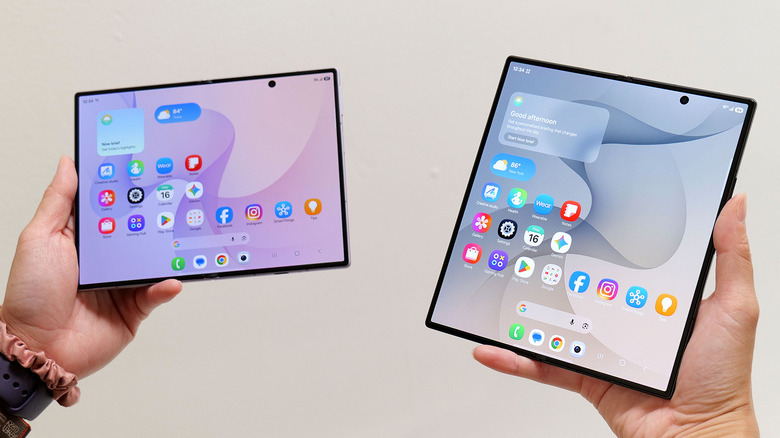 The Samsung Galaxy Z Fold 8 and Z Fold 8 Ultra held up, unfolded, in front of a white wall.