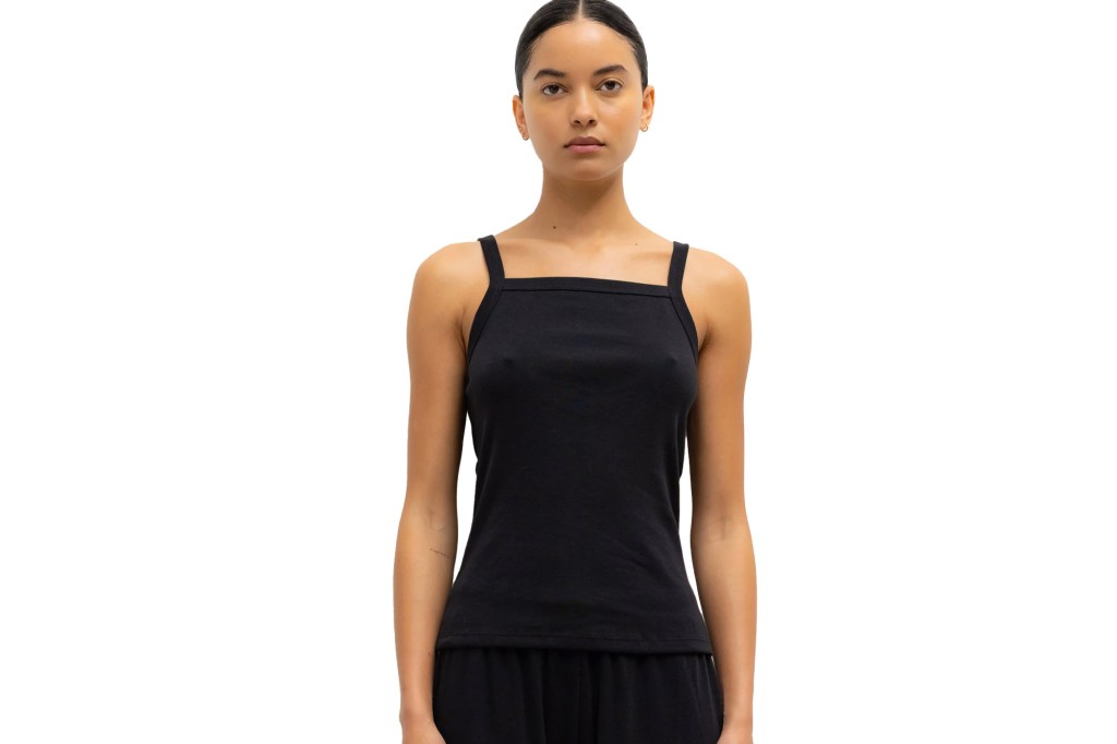 A woman wearing a black tank top and black pants.