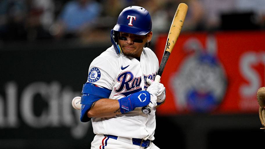 Texas Rangers left fielder Alejandro Osuna is hit by a pitch.