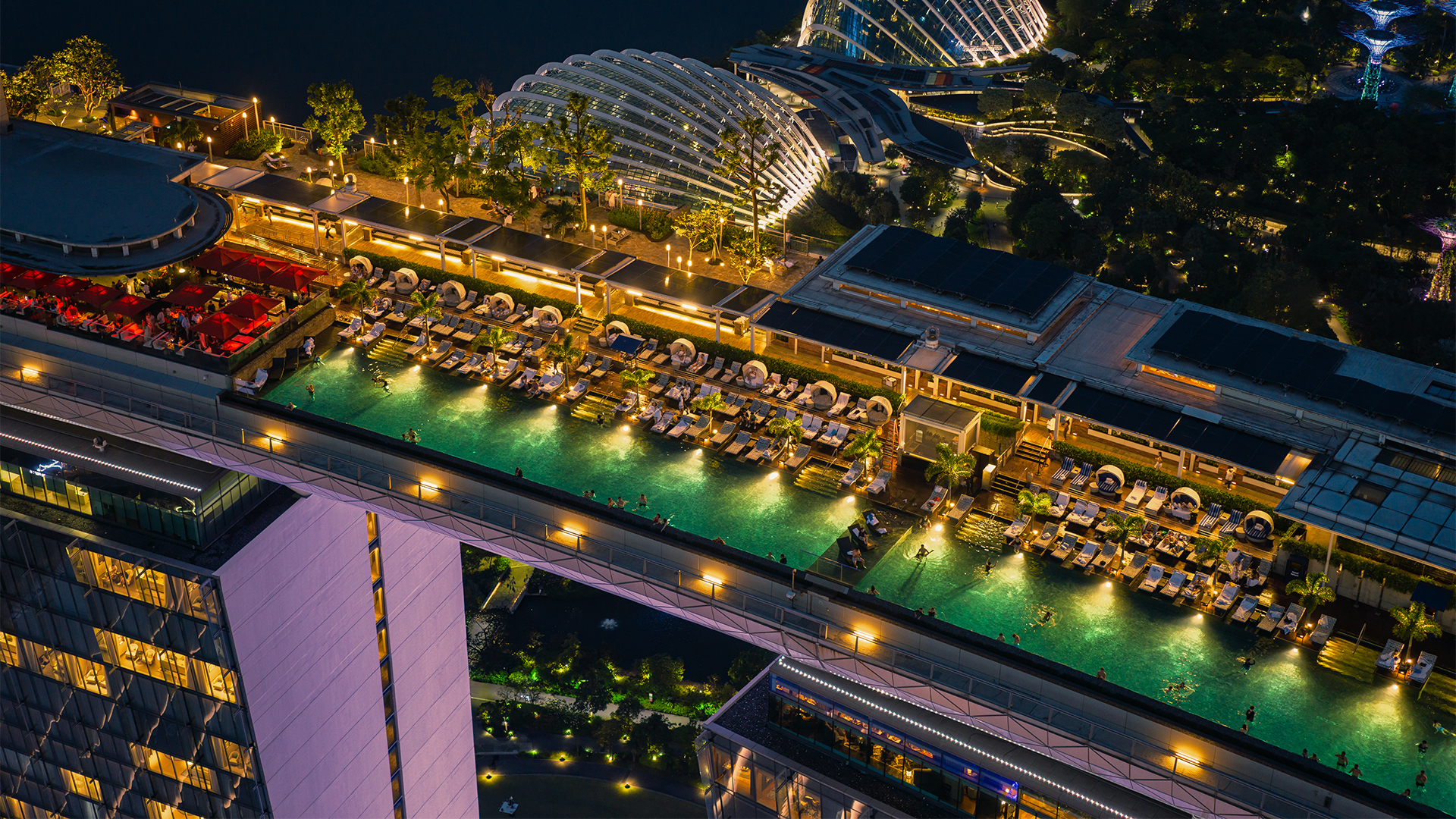 A drone shot of the Marina Bay Sands infinity pool at night