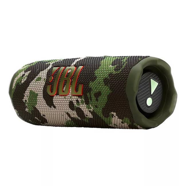 JBL speaker with a camouflage pattern, featuring a bold JBL logo. It's a portable audio device suitable for outdoor use