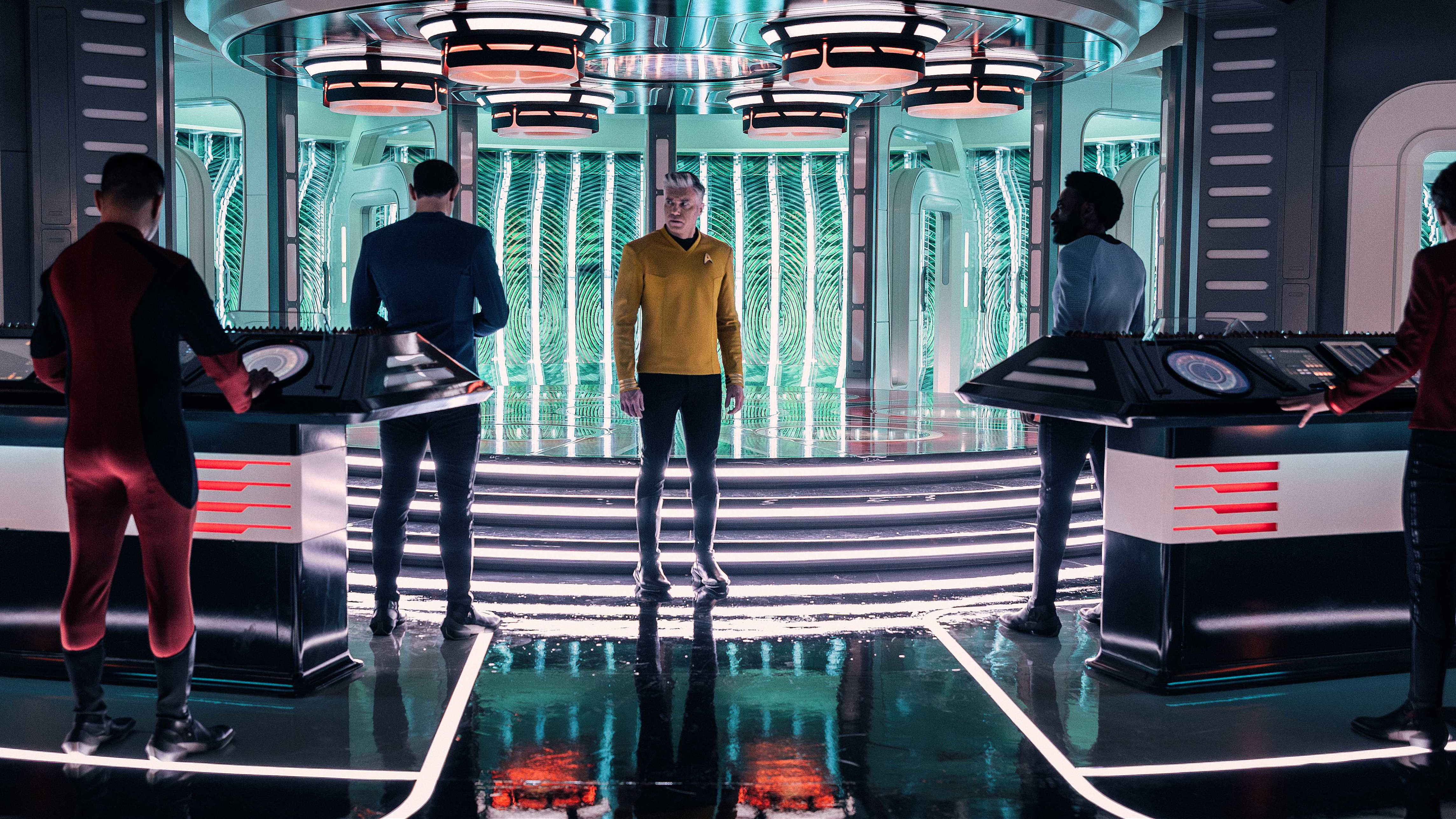 Captain Pike faces Spock, M'Benga, and two redshirts in front of the transporters in Star Trek Strange New Worlds
