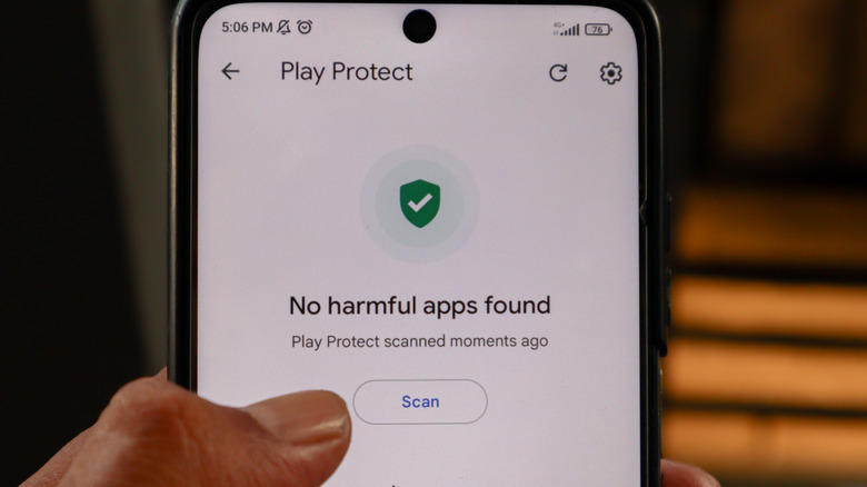 A phone with Google Play Protect on screen, indicating "No harmful apps found."