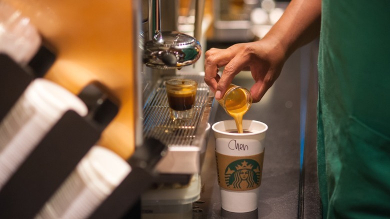 A Starbucks barista preparing a drink.