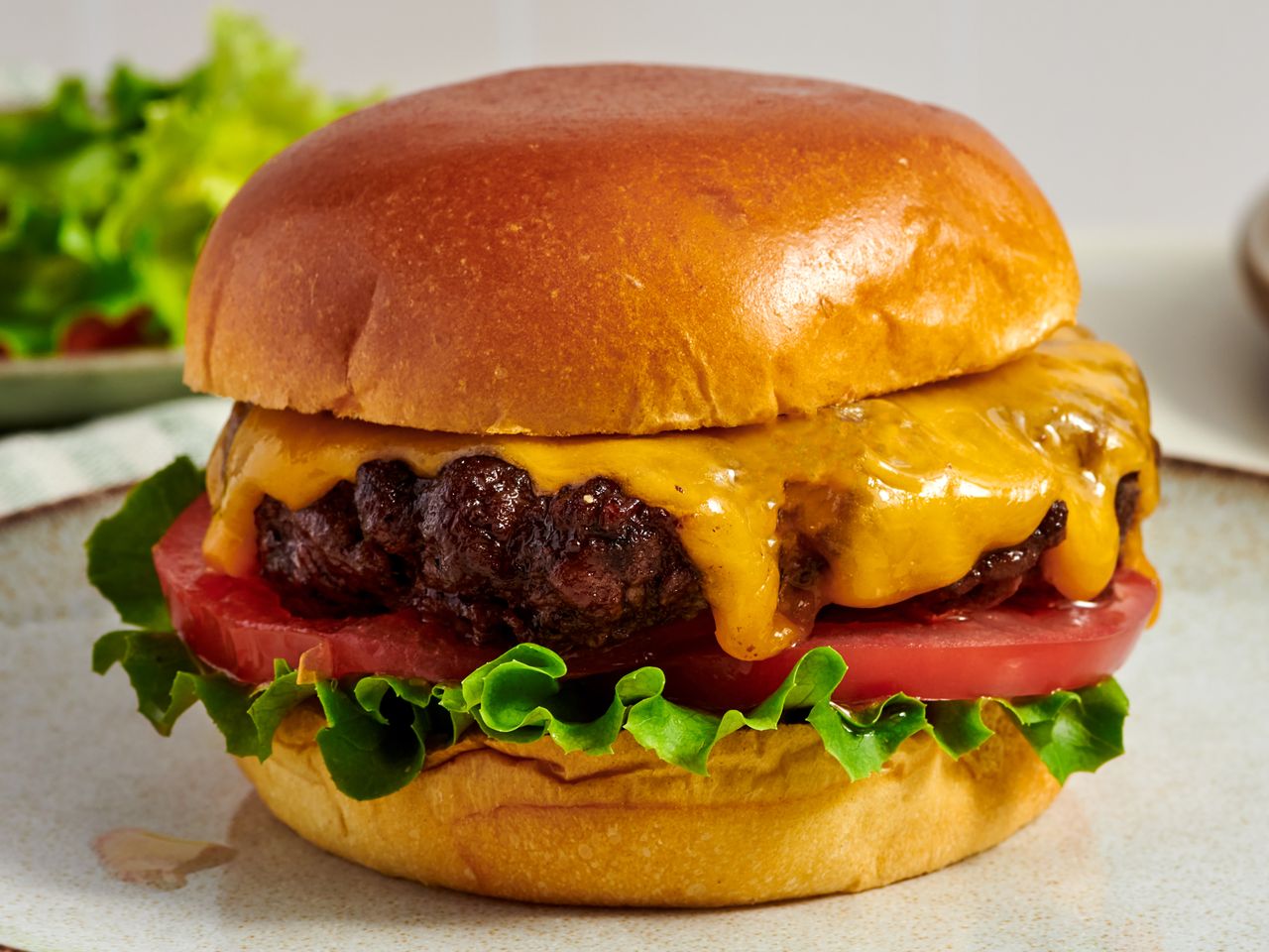 Cheeseburger with lettuce tomato and melted cheese on a bun